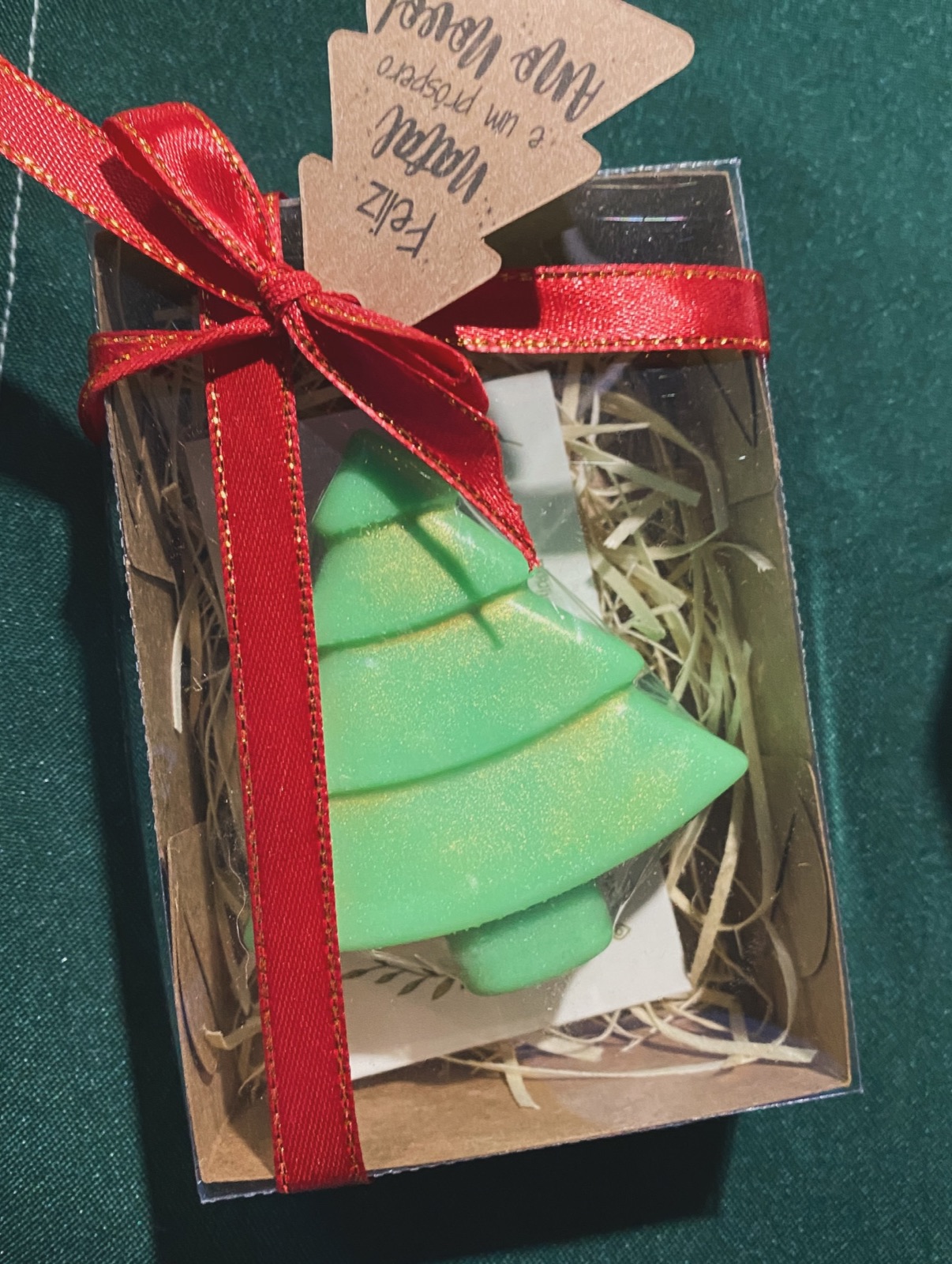 Sabonete verde em forma de árvore de Natal numa caixa kraft com visor e laço vermelho