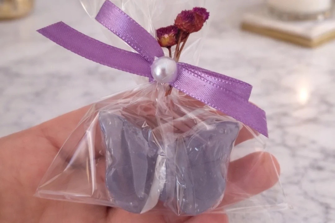 Lembrancinha lilás com laço de cetim e pérola