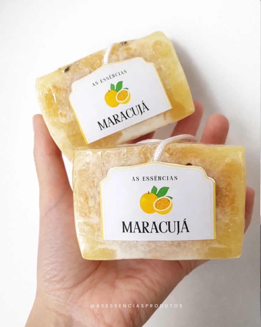 Dois sabonetes de maracujá com bucha vegetal na mão